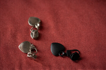 deslizadores para cremallera con forma de corazón sobre tela satinada color marrón © AnaPliego