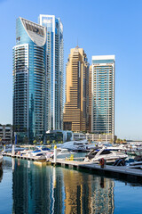 Fototapeta premium Vertical view of Dubai Marina luxury yachts and skyscrapers