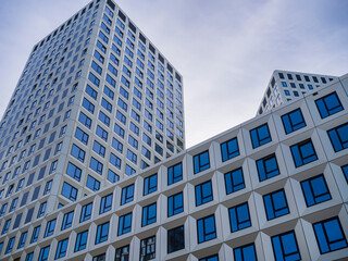 Obraz premium Modern white tower buildings with geometric facade pattern, contemporary architecture