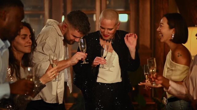 Diverse group of friends dancing and laughing with champagne flutes at a sophisticated evening party celebration