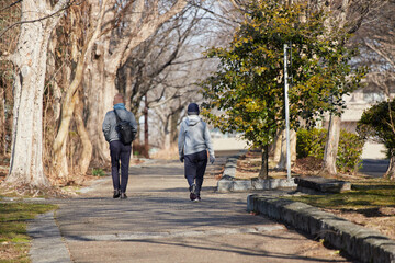 冬の朝の公園でジョギングする中年夫婦の姿