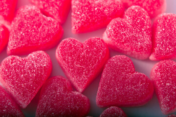 Obraz premium Top view of heart-shaped gummy candies covered in sugar crystals