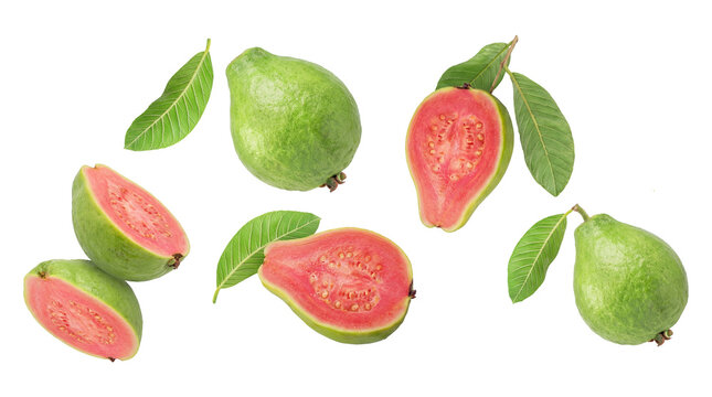 arrangement of fresh pink guavas, whole and halved, with green leaves, isolated on black.