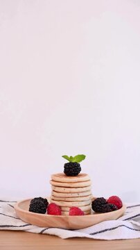 Healthy Breakfast Preparation: Garnishing Pancakes with Blackberry and Mint