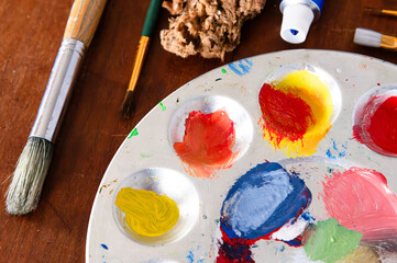 Obraz premium Top view of a paint pallette and paint supplies, including brushes