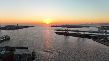 Fototapeta premium Osaka, Japan at sunset: Aerial Drone View of Tempozan Bridge, Tempozan Wharf, Harbour, Port of Osaka, Harbour, Osaka Bay, Ferris Wheel, City Skyline, Evening Colours in Konohana and Minato Ward