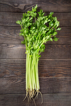 fresh celery with leaves on wooden table.