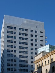 Obraz premium Modern white office building facade with many windows against a clear blue sky