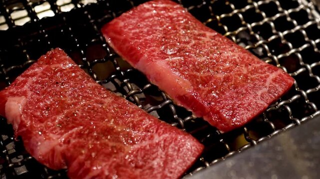 Close Up of Marbled Beef Slices Grilling on Wire Rack