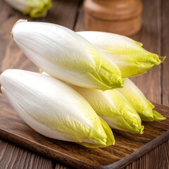 Endives stacked on a wood board; clean and simple, showing texture and color variation