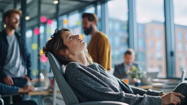 Professional Working in Open Office With Team Behind