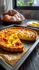 Elevated view of savory quiche with cut wedge atop baking sheet on dark wood
