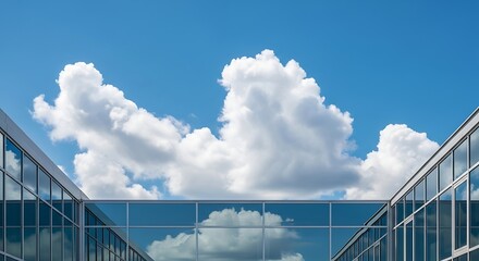 Modern glass building with cloudy sky.
