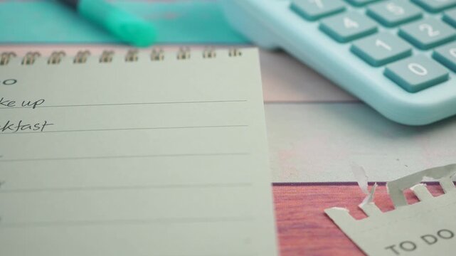 Todo Notepad and calculator on a wooden table for planning tasks