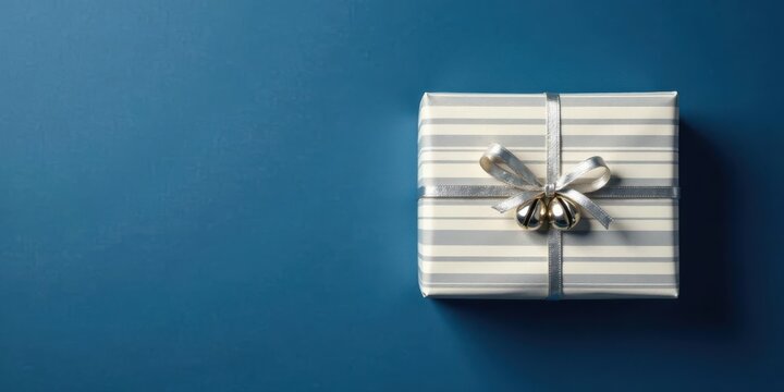 A Beautifully Wrapped Present with Silver Ribbon and Bells on a Deep Blue Background