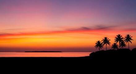 Idyllic tropical sunset scene with silhouetted palm trees and island in the calm sea, under a vibrant pink and orange sky