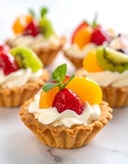 Colorful fruit tarts with cream filling and fresh fruit toppings, sitting on a marble surface