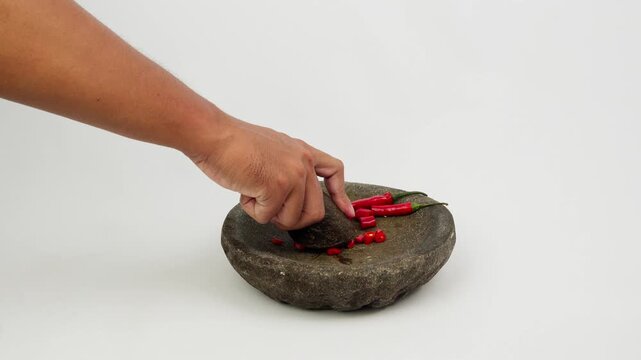 Grinding Red Chili Using Traditional Stone Mortar and Pestle