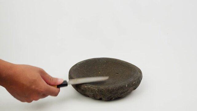 Sharpening Kitchen Knife on Traditional Stone Mortar