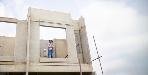 japanese Professional Architects Engineer working at construction site. Asian Man Architect or contractor working on house building under construction site. Civil Engineering in safety harthat helmet