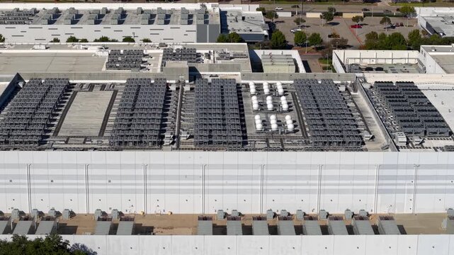 Drone footage reveals a large-scale data center complex with extensive cooling and chiller units on the rooftops