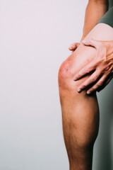 Inflamed human leg with thrombophlebitis, person holding painful limb in clinical setting for medical education with detailed skin texture and copy space background
