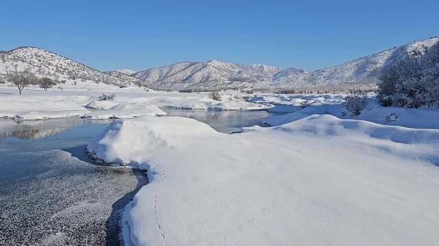 A frozen lake reflects snowy hills and distant mountains under a clear sky, capturing the serene beauty of untouched winter nature.
📍Marivan, Kurdistan 