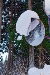 雪が積もったカーブミラー