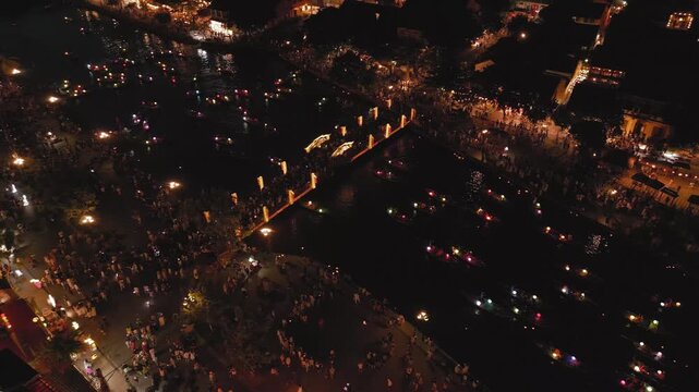 Aerial Night Pan Over Hoi An River With Lantern Boats And City Lights