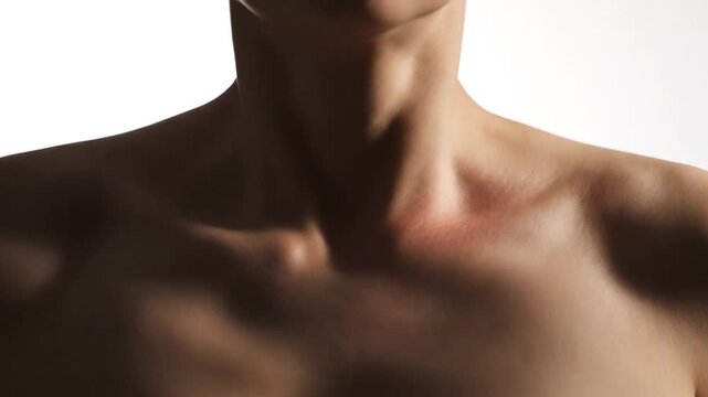 Close up of a mans neck and shoulders in shadow.