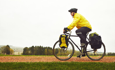 Fototapeta premium Mature man, riding and bicycle in woods for fitness, exercise and endurance challenge. Space, male person and cycling with bike of cardio training, workout safety and physical activity in countryside