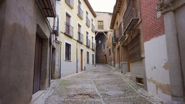 Streets with old buildings and passageways under the buildings in the medieval city of Toledo.