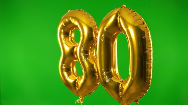 Golden number 80 birthday balloon floating on green screen background
