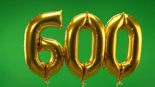 Golden foil balloon number 600 floating on green screen chroma key