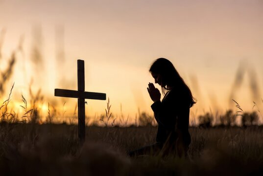 Woman praying at wooden cross sunset field emotional faith spirituality outdoor