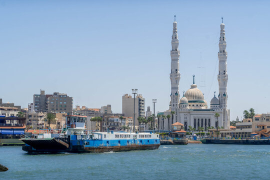 Suez Canal with Port Fuad Grand Mosque panorama overlooking Egypt major navigation waterway.
