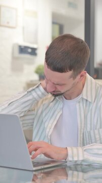 Creative Young Man having Neck Pain at Work, vertical video
