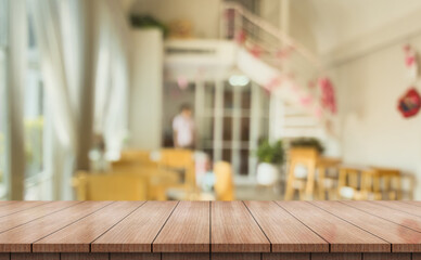 Empty wooden table top with lights bokeh on blur restaurant background.