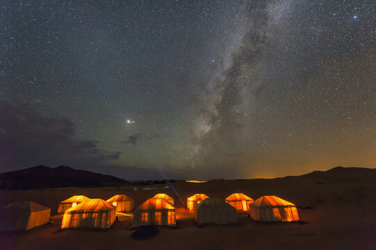 Scenic night sky with star trails at sand dunes desert