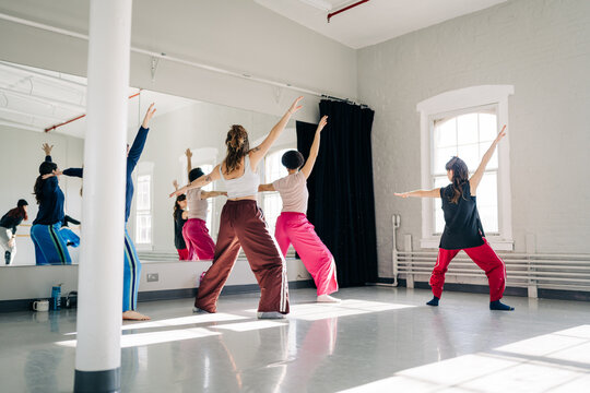 Women practicing dance movements in modern studio