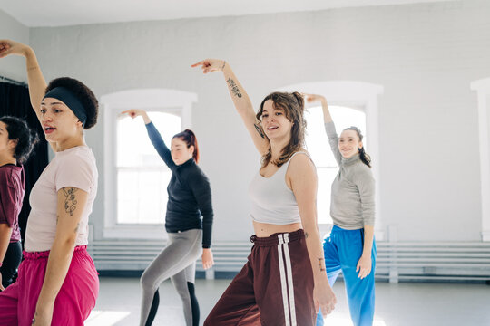 Women dancing synchronized choreography in a bright studio