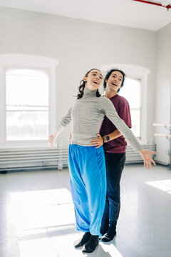 Young women laughing practicing dance moves together