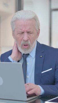 Old Businessman having Neck Pain at Work, vertical video