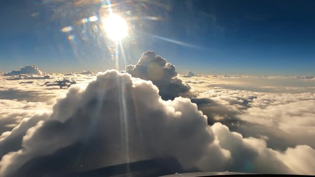 Majestic aerial drone perspective gliding through luminous white cumulus clouds under a brilliant midday sun within a clear blue sky cinematic atmosphere high altitude flight