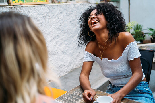 Happy woman laughing, enjoying conversation with friend