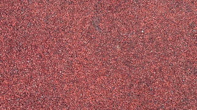 Red Gravel Surface, Compact Stones Create Sturdy Foundation, Earthy Tones With Fine Granules Ensure Durability, Slip resistant Gravel Provides Reliable Footing For Sports Facilities.