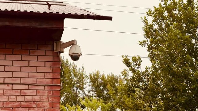Surveillance Device Installed On Brick Wall, Remote Monitoring Camera With High resolution Capabilities, Exterior Dome Security Camera Observing Residence Perimeter With Smart Analytics.