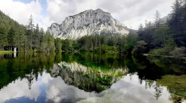 Stunning mountain reflection in the crystal clear Gr&uuml;ner See lake with alpine forest, Styria, Austria