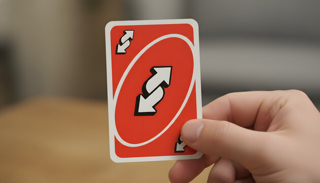 Close-Up Shot of Hand Holding a Red Uno Reverse Card