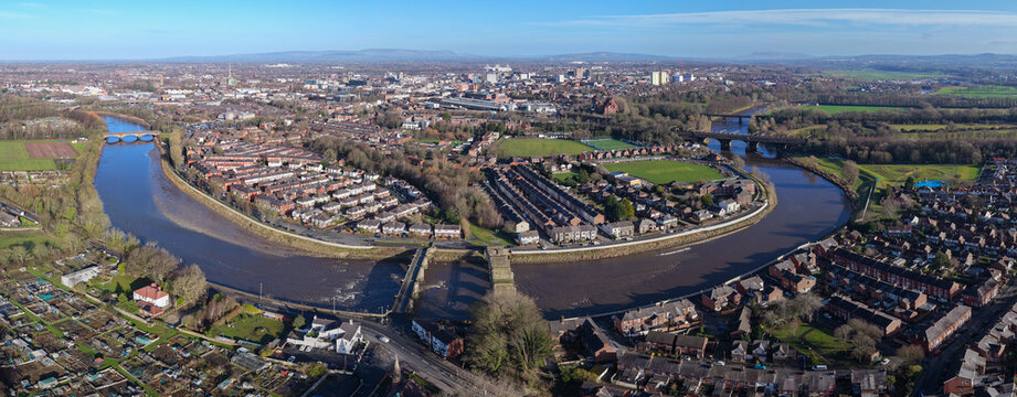 A comprehensive aerial panorama of Preston, Lancashire, featuring the winding River Ribble, historic stone bridges, Victorian parkland, and the urban city skyline.